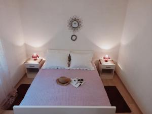 a bedroom with a bed with two tables and a clock at Apartman Antonela in Komin