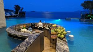 a bar on the side of a swimming pool at night at Boton Blue Hotel & Spa in Nha Trang