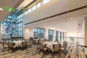ein Konferenzraum mit Tischen und Stühlen und Fenstern in der Unterkunft DoubleTree by Hilton Hotel Cedar Rapids Convention Complex in Cedar Rapids