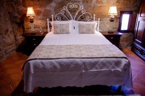 a bedroom with a large white bed with two lamps at Bosque Encantado in Beire