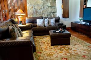 a living room with leather couches and a tv at Bosque Encantado in Beire