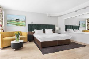 a bedroom with a bed and a couch and a table at Hotel Moderno Poznań in Poznań +31 photos