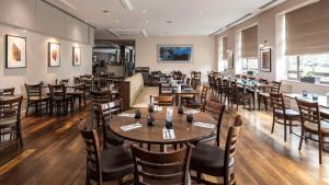 a dining room with wooden tables and chairs at DoubleTree by Hilton Swindon Hotel in Swindon