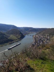a barge traveling down a river with a city at Ferienwohnung Oberreiter in Treis-Karden +3 photos