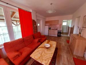 a living room with a red couch and a table at Harkály Nyaraló in Tiszakécske