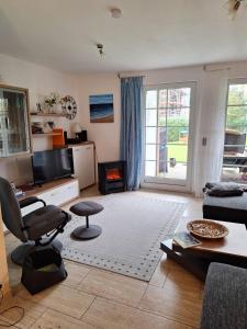 a living room with a couch and a chair and a table at Ferienhaus Möwennest 18 in Tossenserdeich
