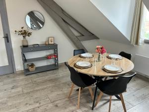 a dining room with a wooden table and chairs at Proche centre - parking securisé in Sainte-Savine