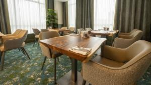 a dining room with tables and chairs and windows at Kenmare Bay Hotel Lodges in Kenmare