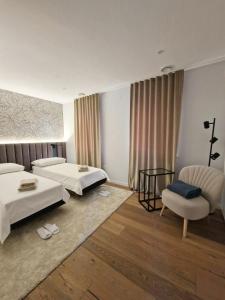 a hotel room with two beds and a chair at Casa Matko in Kostanjevica na Krasu