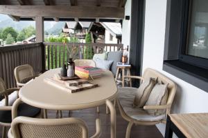 a table and chairs on a balcony with a table and a table at Schönblick Appartements in Lofer