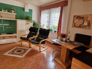 a living room with two chairs and a table at Ferienwohnung Am Öpitzer Berg in Pößneck