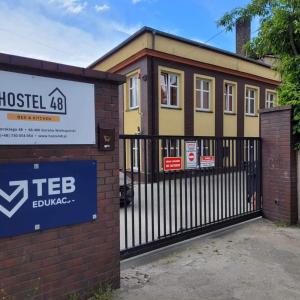a house with a sign in front of a fence at Hostel48 in Gorzów Wielkopolski