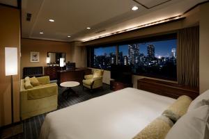a hotel room with a bed and a large window at Grand Prince Hotel Takanawa in Tokyo