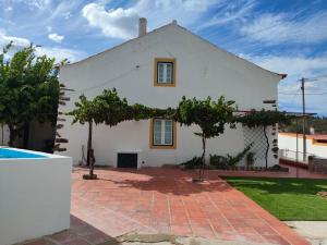 a white house with trees in front of it at Casa do Duque in Arneiro