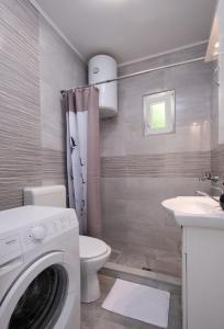 a bathroom with a washer and a toilet and a sink at Lucky Bay - Comfort & Terrace Vibes in Mlini +2 photos