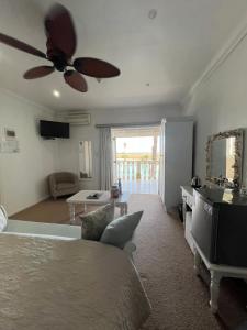 a living room with a bed and a ceiling fan at Russells on the Port in Velddrif