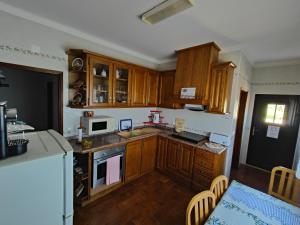 a kitchen with wooden cabinets and a counter top at Alojamento Local Céu-Azul in Porto de Mós