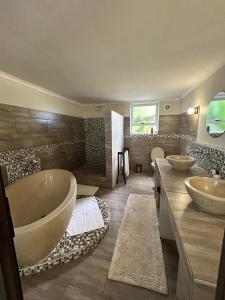 a bathroom with two sinks and a large tub at Calla Lily Guesthouse in Nelspruit +76 photos