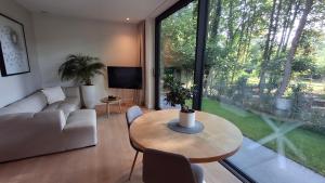 a living room with a table and a large window at Privé studio in groene omgeving van Brugge gratis fietsen & parkeerplaats in Bruges