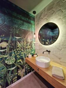 a bathroom with a sink and a mural of plants at Casa Matko in Kostanjevica na Krasu +16 photos