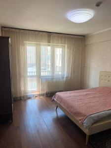 a bedroom with a bed and two large windows at Guest House Ulaanbaatar in Ulaanbaatar