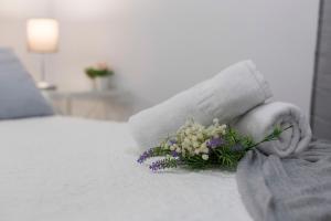 a person holding a bouquet of flowers on a bed at Plaza Caballo 3 Dormitorios Vistas in Jerez de la Frontera