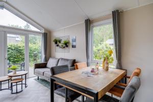 a living room with a table and a couch at Modern chalet op de Veluwe in Epe