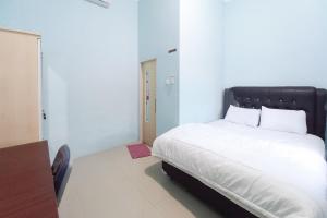 ParitReGa GuestHouse RedPartner的一间卧室配有一张白色的床和黑色床头板