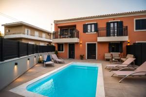 a swimming pool on a patio next to a building at Corfu Mylos in Ágios Nikólaos