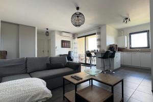 a living room with a couch and a table at Appartement Le 202 - Tain l'Hermitage in Tain-lʼHermitage +7 photos