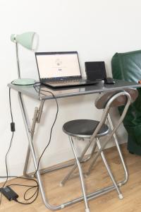 ein Schreibtisch mit einem Laptop darauf in der Unterkunft Cloud Nine, 5mins ORLY Airport in Athis-Mons