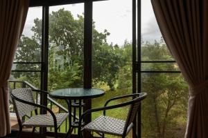 a table and two chairs in front of a window at Mon View Ngam in Chiang Mai
