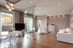 uma sala de estar com um sofá branco e uma mesa em UNYCA - River View Suite em Florença