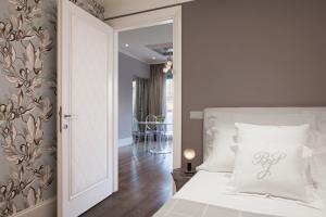um quarto com uma cama branca e um quarto com uma mesa em UNYCA - River View Suite em Florença