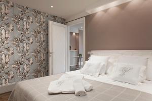 um quarto com uma cama branca com travesseiros brancos em UNYCA - River View Suite em Florença