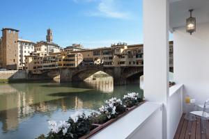 uma vista de uma ponte sobre um rio com flores em UNYCA - River View Suite em Florença