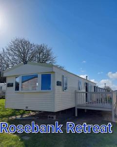 a mobile home with a porch and a deck at Rose bank Retreat in Hunmanby +3 photos