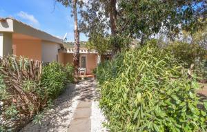 a house with trees and a pathway in front of it at Bilocale in Costa Rei +13 photos