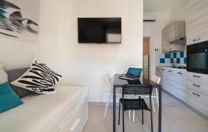 a living room with a couch and a table with a laptop at Bilocale in Costa Rei