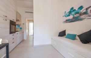 a white kitchen with a white couch in a room at Bilocale in Costa Rei