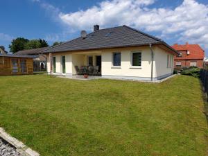 a small white house with a yard at Am Krabbenweg Whg.2 im Haus Am Krabbenweg in Insel Poel