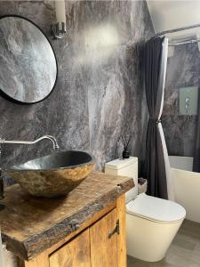 Beautiful Character Cottage - with Hot Tub في بودمين: حمام مع حوض حجري ومرحاض +40 صورة