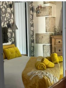 Beautiful Character Cottage - with Hot Tub في بودمين: غرفة نوم عليها سرير ومخدات صفراء