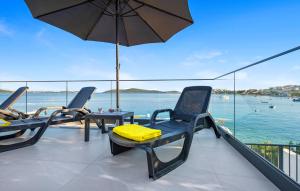 einen Balkon mit 2 Stühlen und einem Sonnenschirm in der Unterkunft Beautiful Home In Sevid in Sevid + 45 Fotos