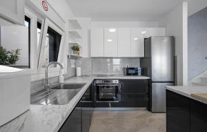 eine Küche mit einer Spüle und einem Kühlschrank aus Edelstahl in der Unterkunft Beautiful Home In Sevid in Sevid