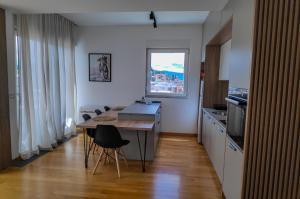 a kitchen with a table with chairs and a window at Golden View Apartment in Ohrid