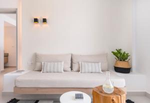 a white living room with a couch and a table at Quartano Suites by Heliessa, Adults Only in Naousa