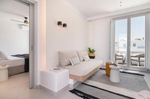 a white room with a bed and a balcony at Quartano Suites by Heliessa, Adults Only in Naousa