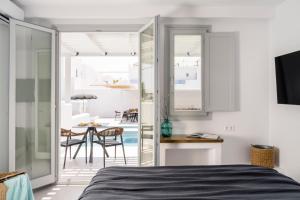 a bedroom with a bed and a dining room at Quartano Suites by Heliessa, Adults Only in Naousa