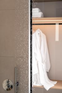 a shower with a white robe on a shelf at Quartano Suites by Heliessa, Adults Only in Naousa